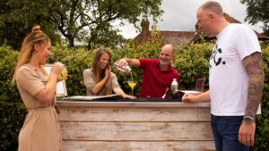 People havig fun mixing cocktails in the garden from a DIY cocktail bar