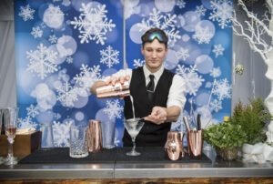 hemed bartender demonstrating virtual Christmas cocktail making